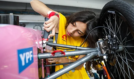 Chica arreglando su auto eléctrico de Desafío ECO YPF